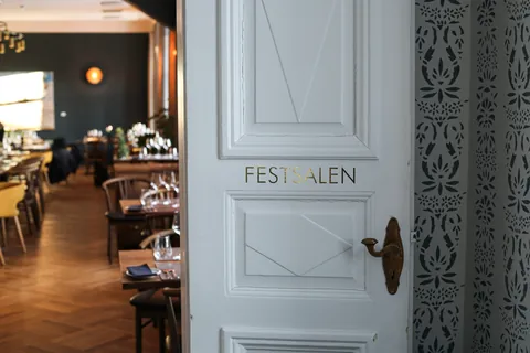 The white double door of the banquet hall, lettered FESTSALEN