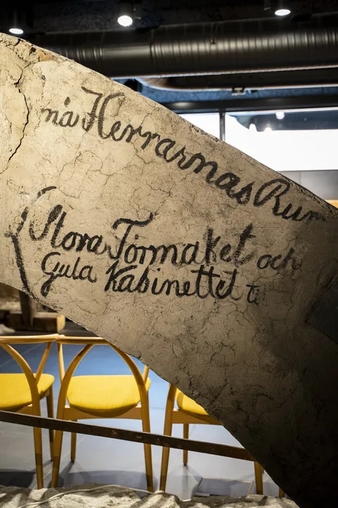 A painted ceiling beam bearing the names of the rooms of the house in Swedish