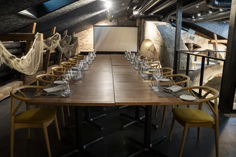 A long laid table in LYHTY beneath the vault, nets from the ceiling
