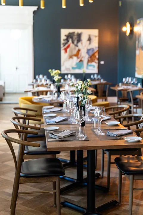 The dining room laid for service, with artwork and brass lighting