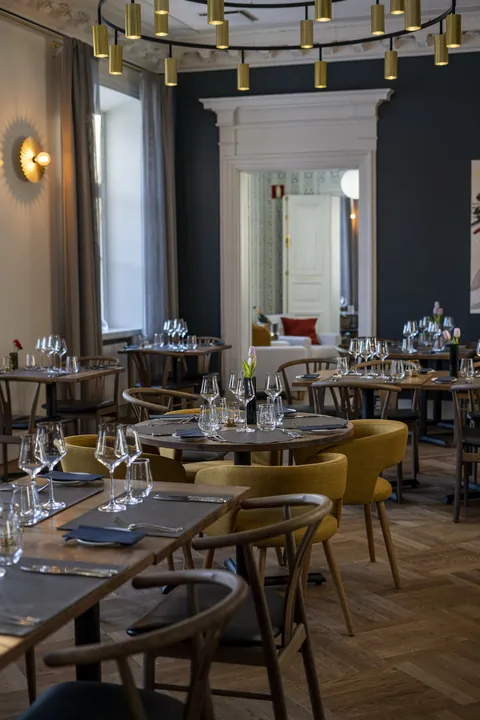 A view through the doorway into the dining room, a brass light ring and herringbone parquet