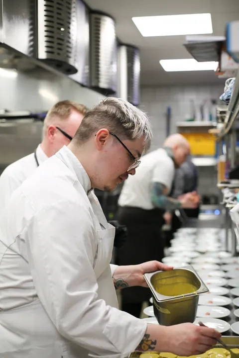 Chefs plating at the kitchen pass