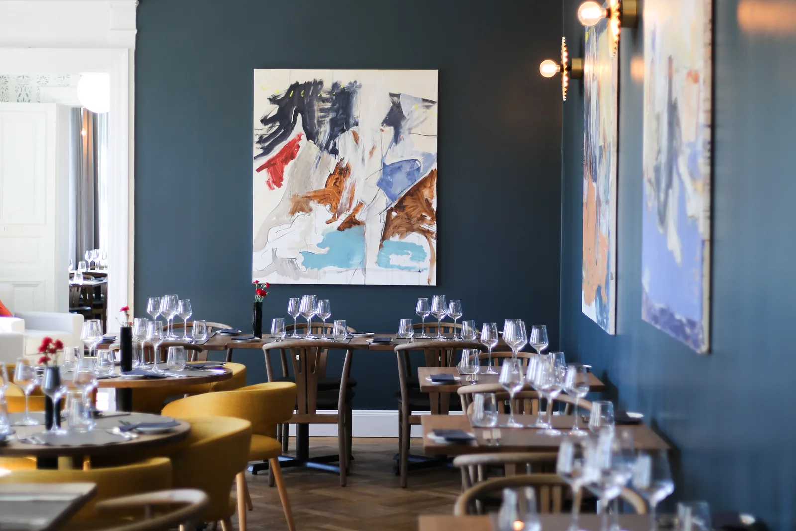 The OOBU dining room, blue walls and yellow armchairs