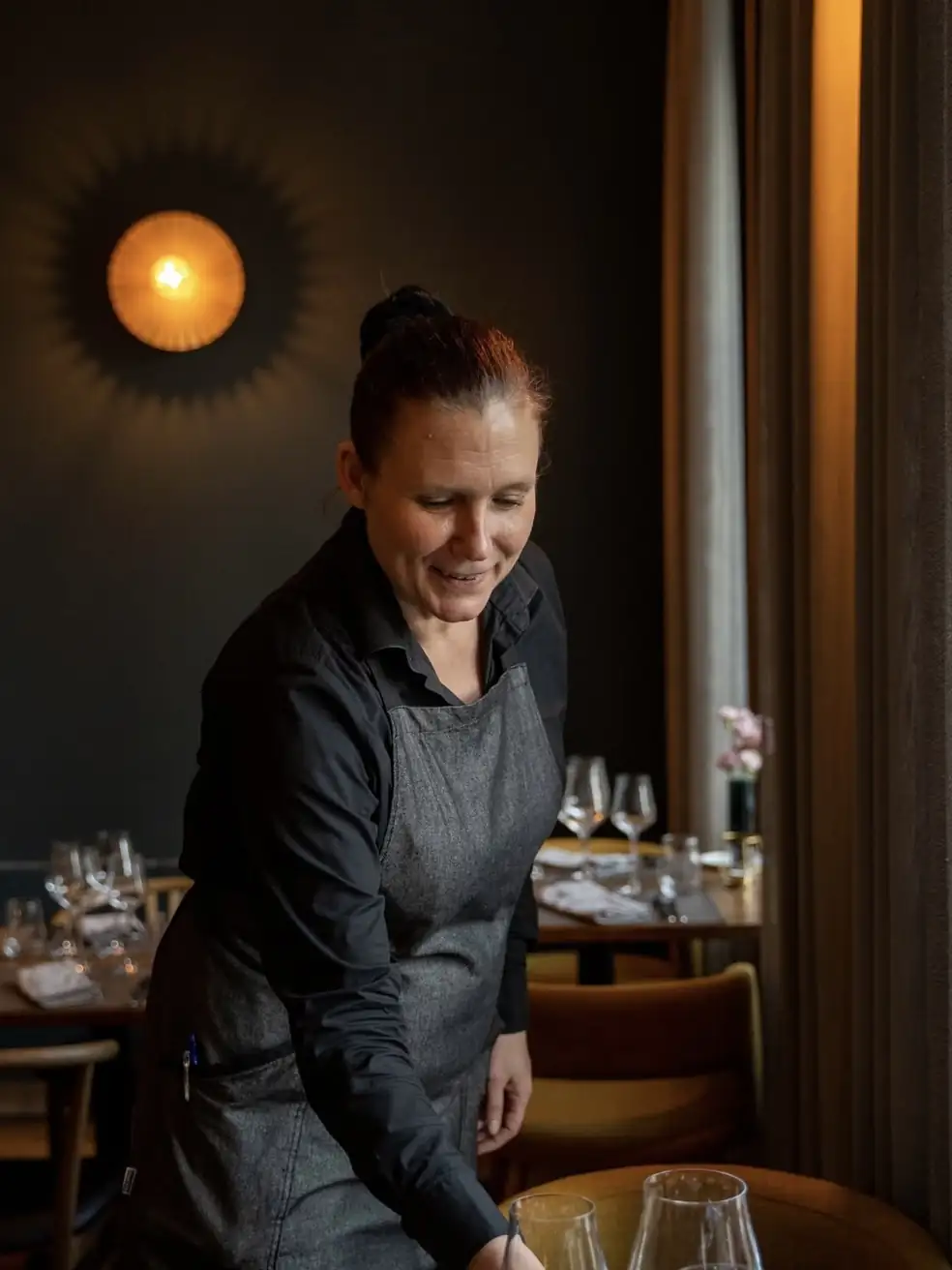 Tarjoilija viimeistelee pöytää salissa